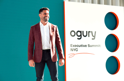 Wil Schobeiri, CTO at Ogury, stands in front of stage that says "Ogury: Executive Summit NYC"